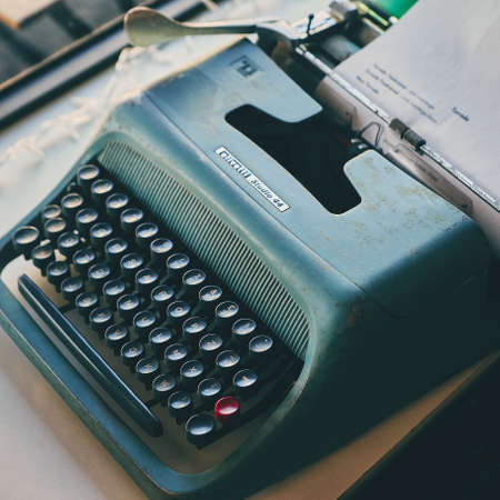 Lisbon, Portugal - February, 2018. Photo of retro objects in the lounge of a cafe in the suburbs of Lisbon. Vintage typewriter of blue-green color with black keys and one red keyのeditorial素材