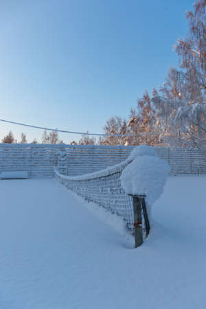 Snow covered tennis net on a cold winter dayの写真素材