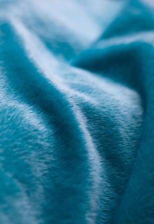 Cyan colored fake fur blanket as waves on natural light