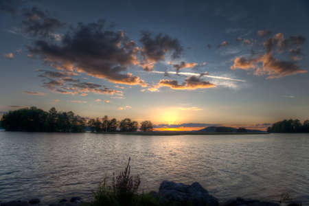 Sundown on horizon behind and islandの写真素材