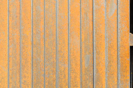 Racks of metal profiles. Metal is stored in an open warehouse. Wet and rusty on the street. Old...