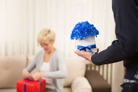 A man brings beautiful flowers to a medieval lady. flowers are blue and in a box.の写真素材
