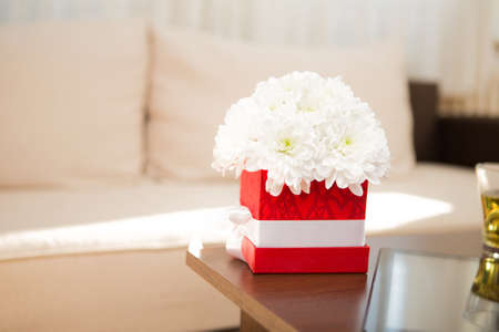 a decorative box full of white chrysanthemums on the table.の写真素材