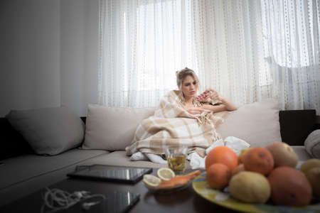 Young beautiful woman does not feel well, she is thinking about taking pills or not.