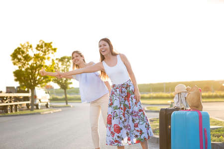 Two beautiful young women trying to stop someone who would transport them.の写真素材
