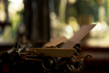 Selective focus on 19th century old black typewriter with blank paper ready for new text. Copy...