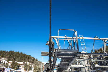 Close-up shot of a mechanism to pull a steel rope on a cable car, and behind it is clear blue skies. Copy Space.の写真素材