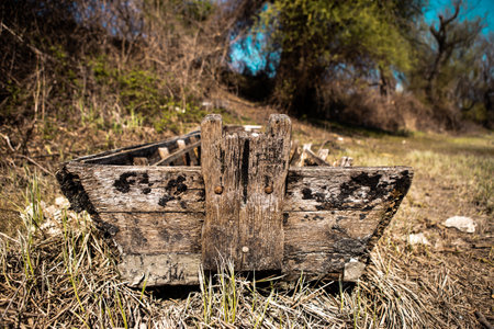 An old wooden boat on the shore, the boat is rotten and no longer for use, and there is a lot of garbage in it and around it, thrown plastic bottles, plastic bags and packaging.の写真素材
