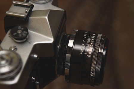 Selective focus on the lens of an old analog camera. The camera is very old and ruined, traces of use are visible.の写真素材