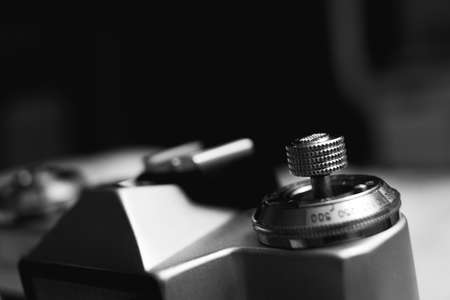 Selective focus on the adjustment button on an old analog camera. Black and white photography. Copy space.の写真素材