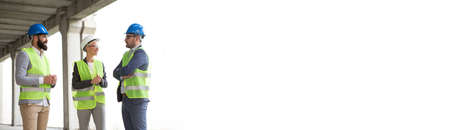 A beautiful female engineer with her handsome colleagues on a construction site.の写真素材