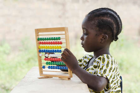 Little african girl counting on abacus frame on blurred backgroundの写真素材