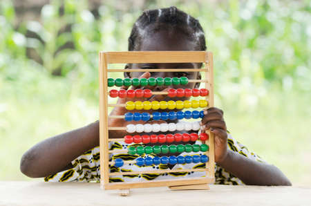 Little african girl counting on abacus frame on blurred backgroundの写真素材