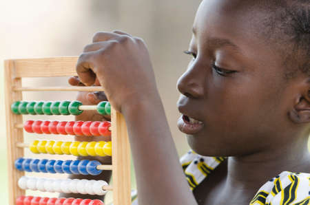 Little african girl counting on abacus frame on blurred backgroundの写真素材