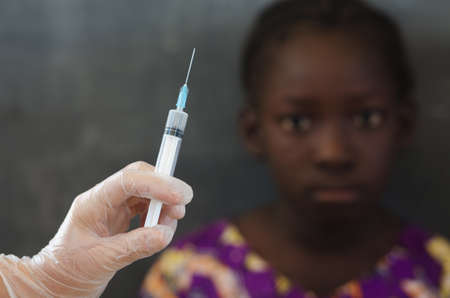 Little African girl getting a needle injection for the first timeの写真素材