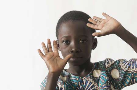African child protecting his face with his hands, isolated on whiteの写真素材