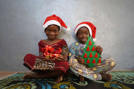 Two Gorgeous African Black Children Present and Christmas Treeの写真素材