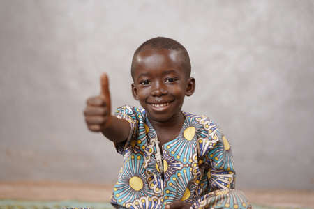 Unbelievably happy African black boy with Thumbs Up and Copy Spaceの写真素材
