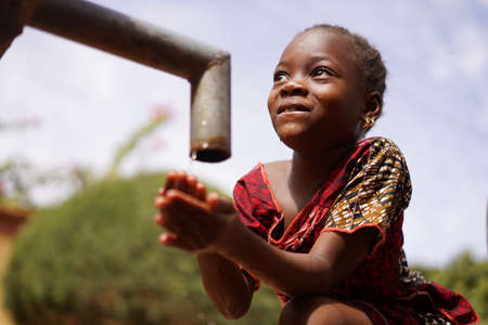 Human Rights Issues, African Black Ethnicity Girl Woman Drinks Fresh Clean Water from Tapの写真素材