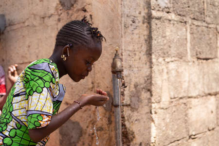 Candid Photograph of African Black Beautiful Girl drinking Freshwaterの写真素材