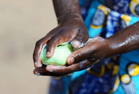 Health Symbol when African Girl Washes Her Hands Strongly with Soap and Sanitizer to avoid contacting Virusの写真素材