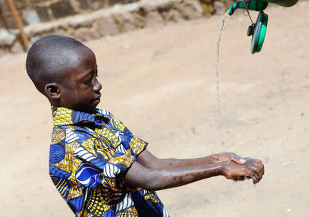 African Boy Washing Hands Properly to Avoid Contamination with Coronavirus or Virus or Bacteriaの写真素材