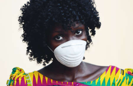 African Woman Close Up Posing with Facial Mask to Protect from Infections from Bacteria, Viruses and...