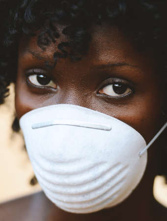 Beautiful African Woman Student Posing with Virus Mask To Protect Herselfの写真素材