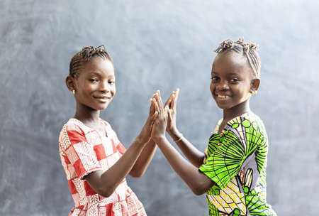 Candid Photo of Two African Children Sisters Girls Women Playing Cheerful Smile with Hands and Facesの写真素材