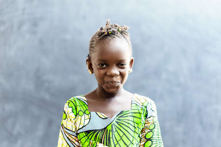 Cute African Beautiful Child Smiling Happy in front of Blackboard in Typical African Classroomの写真素材