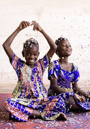 Portrait View of African ethnic group of children enjoying party indoors with confettiの写真素材