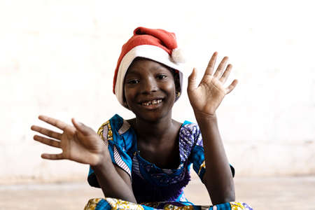 Gorgeous African Schoolgirl posing for Christmas with Hat and Hands Openの写真素材