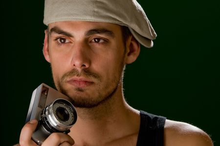 Portrait of a young photographer against a dark green background