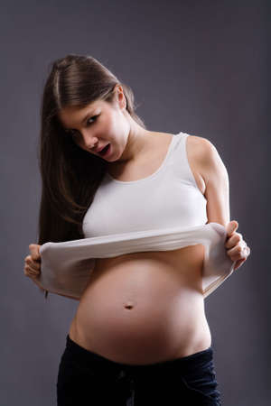 Young pregnant female showing her abdomen.の写真素材