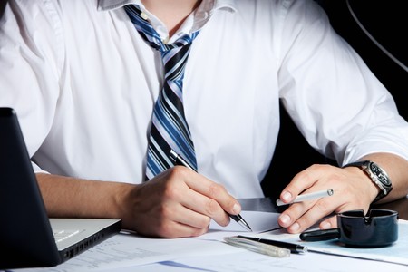 Unrecognizable businessman working and smoking at his desk.の写真素材