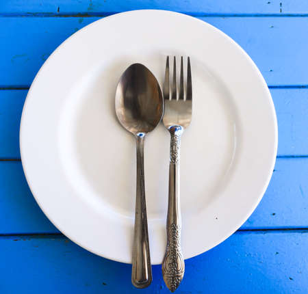 Empty plate and fork on wood table