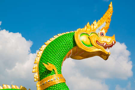 Thai dragon or Naga statue with blue sky background at Thailandの写真素材