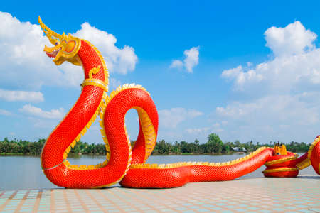 Thai dragon or Naga statue with blue sky background at Thailandの写真素材