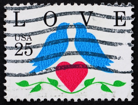 UNITED STATES OF AMERICA - CIRCA 1990: a stamp printed in the United States of America shows two birds with heart and word love, circa 1990の写真素材