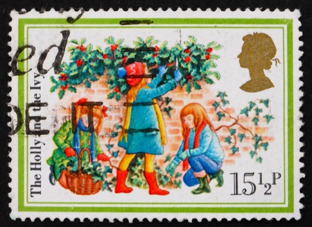 GREAT BRITAIN - CIRCA 1982: a stamp printed in the Great Britain shows Three girls, the holly and the ivy, Illustration for Christmas carol, circa 1982の写真素材