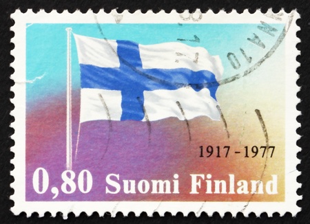 FINLAND - CIRCA 1977: a stamp printed in the Finland shows Finnish Flag, 60th Anniversary of Finlands Declaration of Independence, circa 1977の写真素材