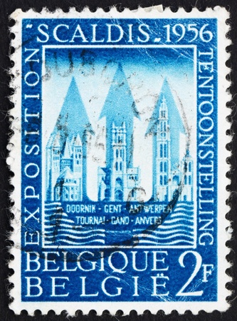 BELGIUM - CIRCA 1956: a stamp printed in the Belgium shows Buildings of Tournai, Ghent and Antwerp, the Scheldt Exhibition, Belgium, circa 1956の写真素材