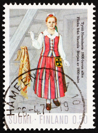 FINLAND - CIRCA 1972: a stamp printed in the Finland shows Girl from Nastola, 19th centenary, regional costume, circa 1972のeditorial素材