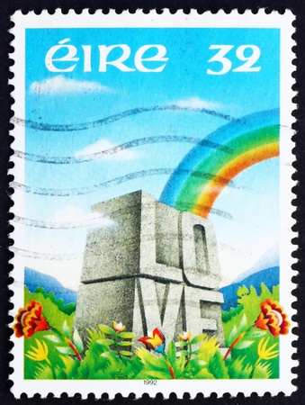 IRELAND - CIRCA 1992: a stamp printed in the Ireland shows Rainbow over Meadow and Word LOVE Etched in Stone, circa 1992のeditorial素材
