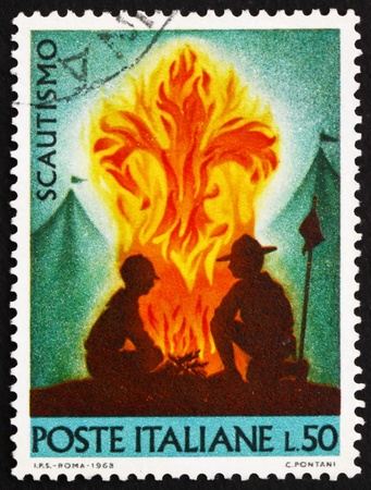 ITALY - CIRCA 1968: a stamp printed in the Italy shows Scouts at Campfire, circa 1968 ITALY - CIRCA 1968: a stamp printed in the Italy shows Scouts at Campfire, circa 1968