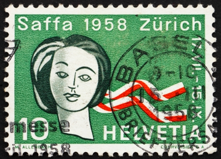 SWITZERLAND - CIRCA 1958: a stamp printed in the Switzerland shows Womans Head and Ribbons in Swiss Colors, Saffa Exhibition, Zurich, Womens Suffrage, circa 1958のeditorial素材