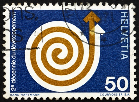 SWITZERLAND - CIRCA 1971: a stamp printed in the Switzerland shows Rising Spiral, 2nd Decade of Development Aid, circa 1971のeditorial素材