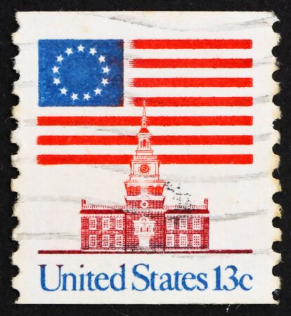 UNITED STATES OF AMERICA - CIRCA 1975: a stamp printed in the USA shows 13-Star Flag and Independence Hall, circa 1975のeditorial素材