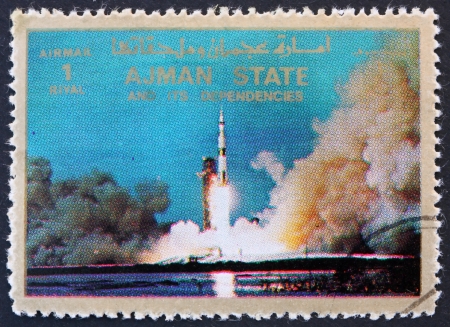 AJMAN - CIRCA 1973: a stamp printed in the Ajman shows Saturn V Rocket Launching, Moon-landing, Apollo 11, circa 1973のeditorial素材