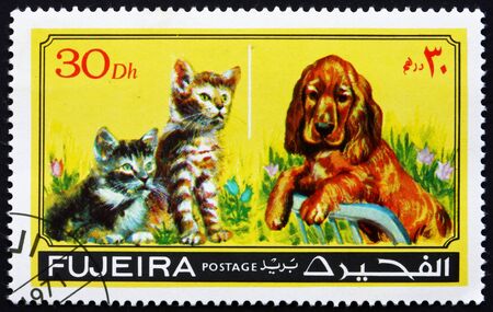 FUJEIRA - CIRCA 1971: a stamp printed in the Fujeira shows Dog and Cat, Pets, circa 1971のeditorial素材